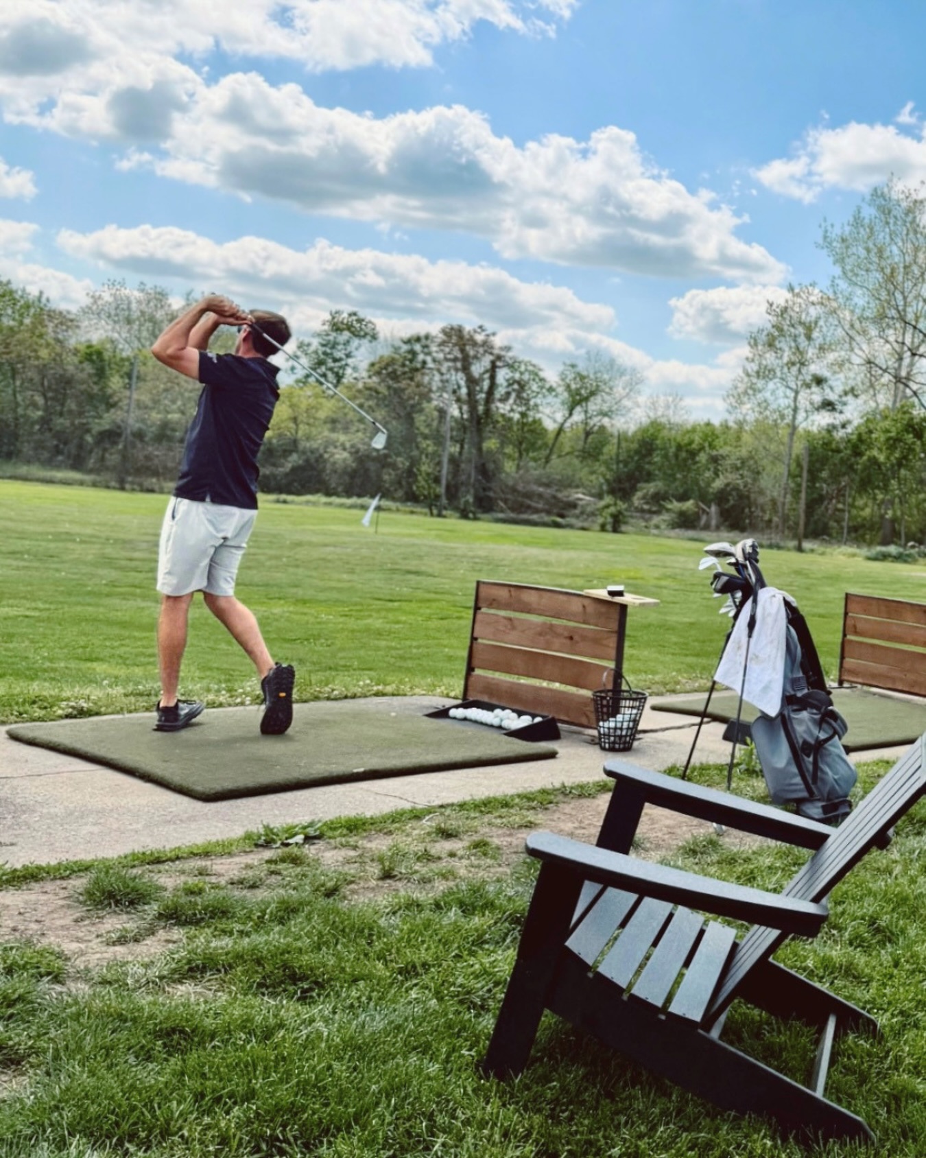 A golfer practicing at The Acres driving range