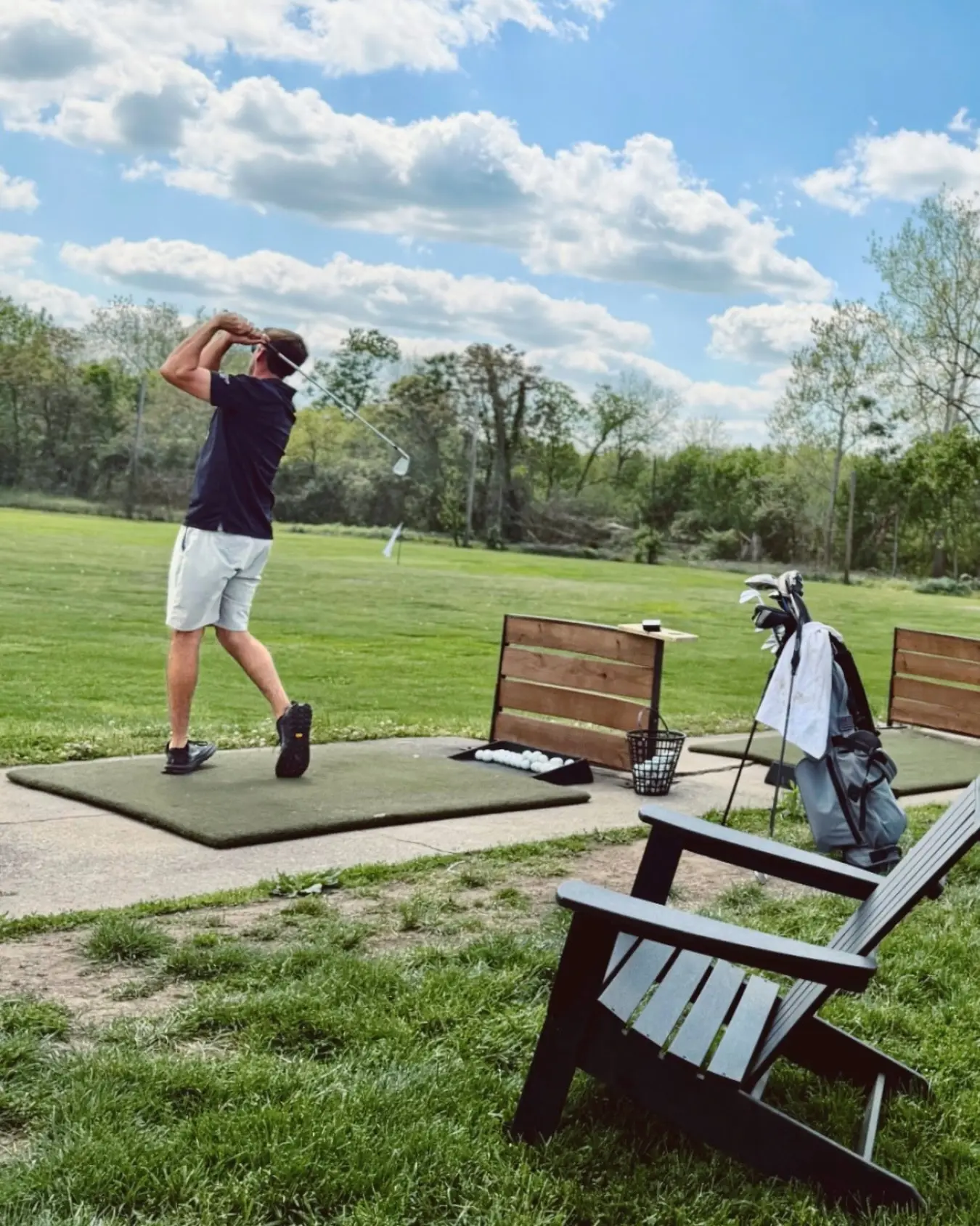 A golfer practicing at The Acres driving range